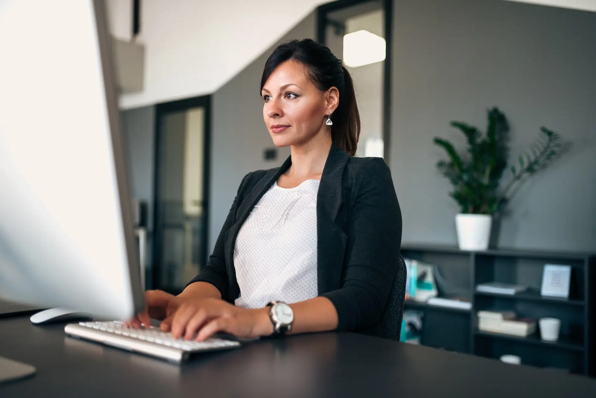 there is a woman sitting at a desk with a computer