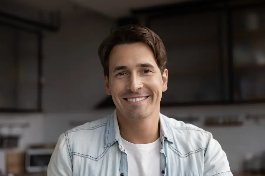man in a white shirt and blue shirt smiling